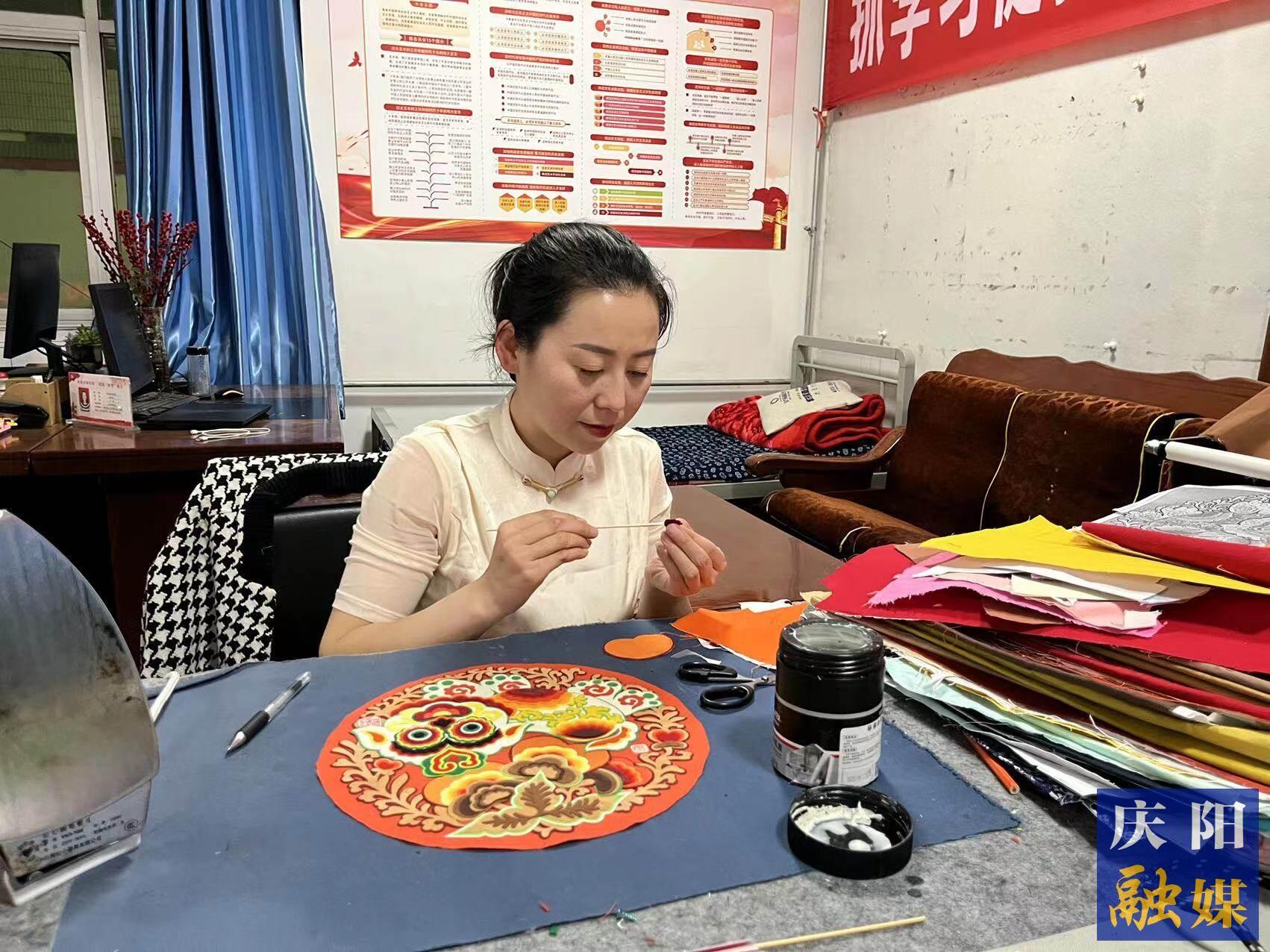 李慶英正在創(chuàng)作布貼畫作品。